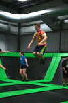 Four People Jumping on Trampolines at Indoor Fun Park